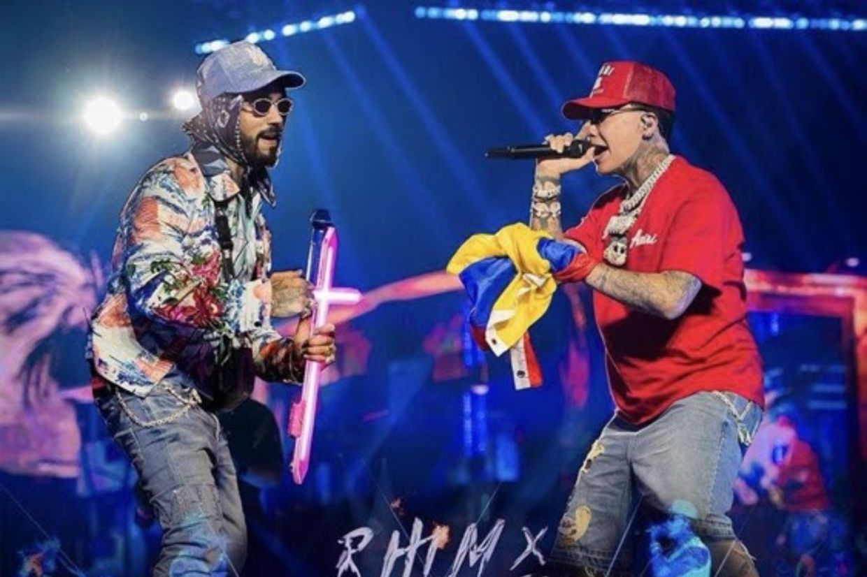 Two singers performing on stage wearing hats.