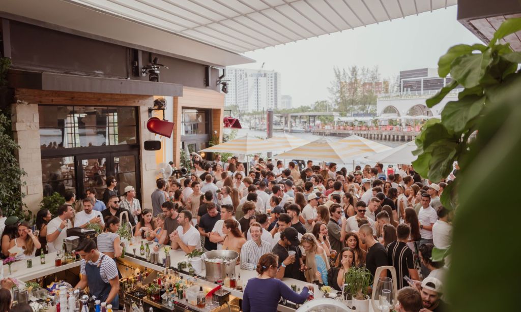 Picture of a party during the day by the water.