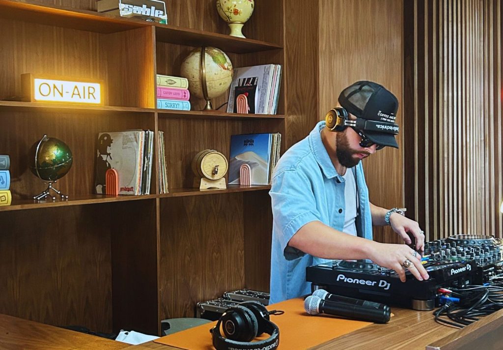 DJ playing in a room with wooden walls