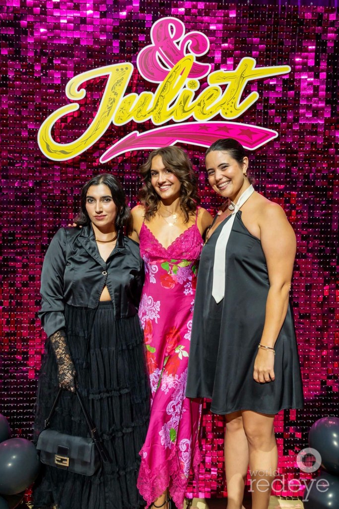 three women post in front of a marquee reading, "&Juliet"