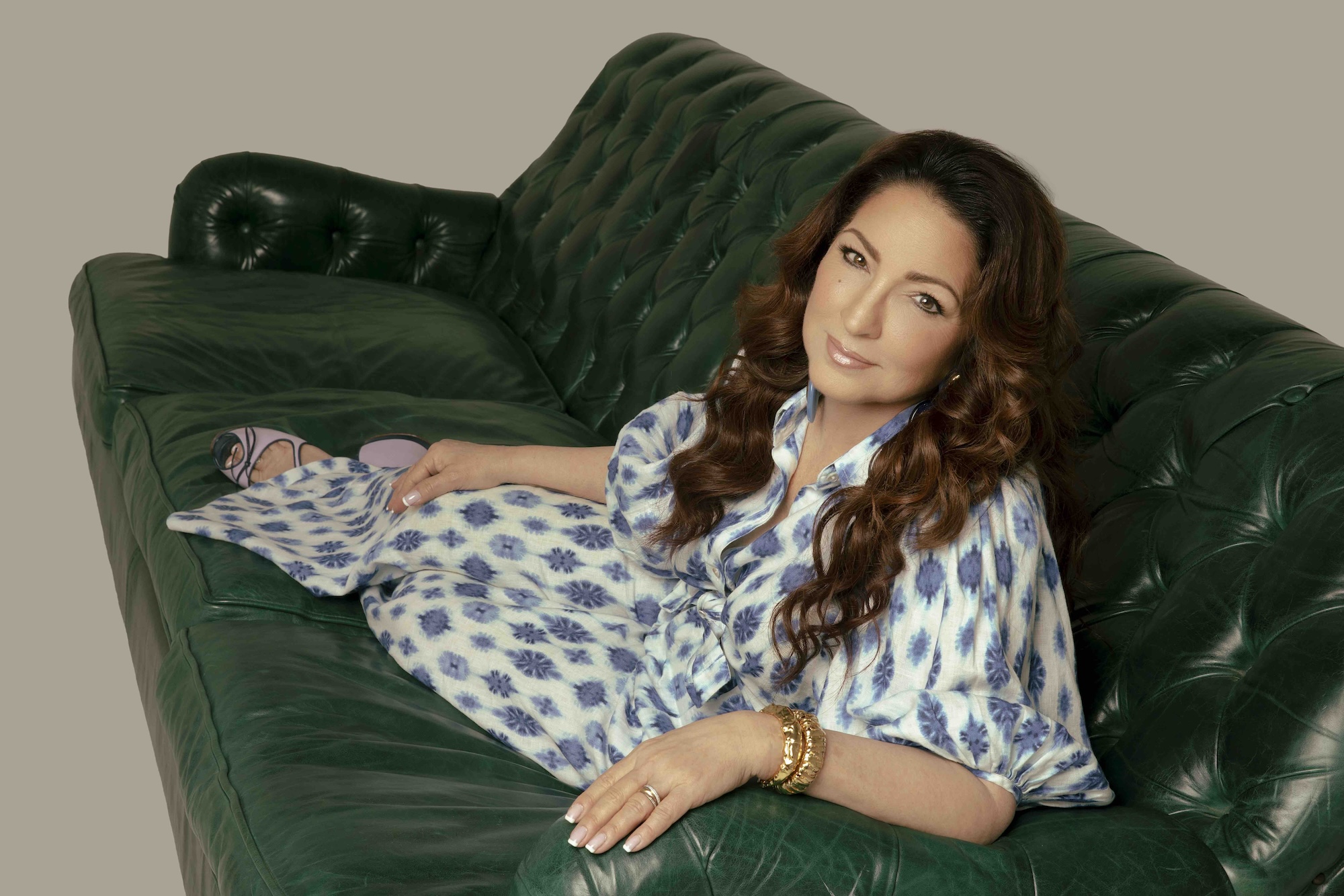 Image of a woman sitting on a green couch.
