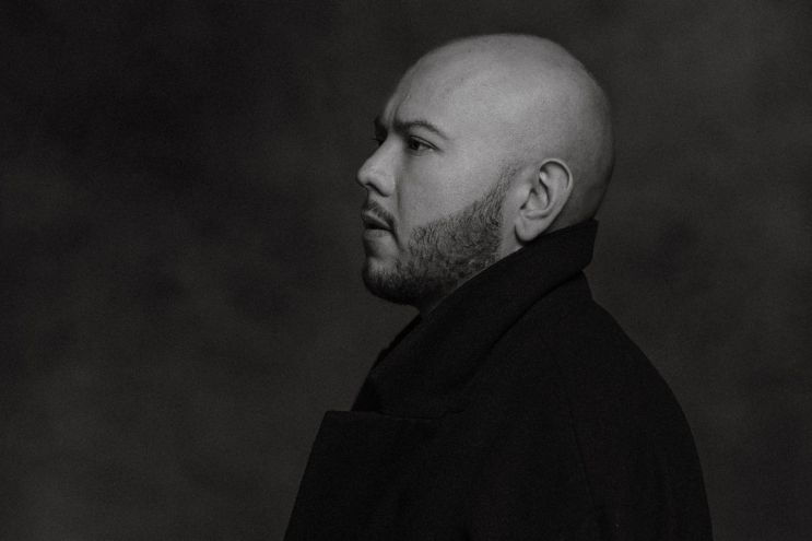Black and white headshot of a bold man.