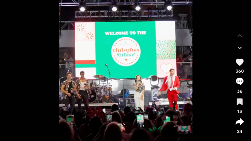 Screenshot of a TikTok video showing two hosts and two singers onstage. A backdrop on the stage reads, "Welcome to the Christmas Cruise"