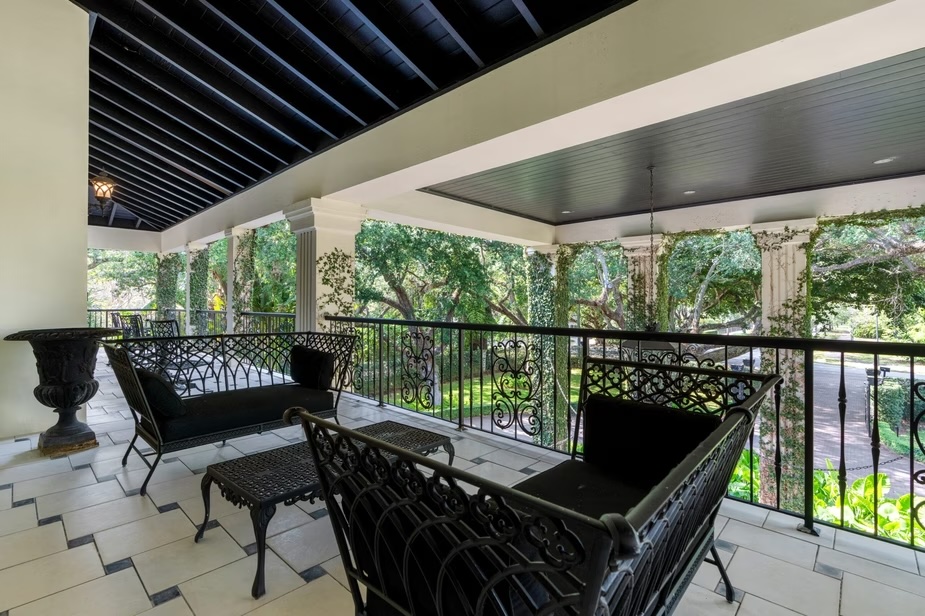 Depicted is a second-story porch overlooking the front driveway.