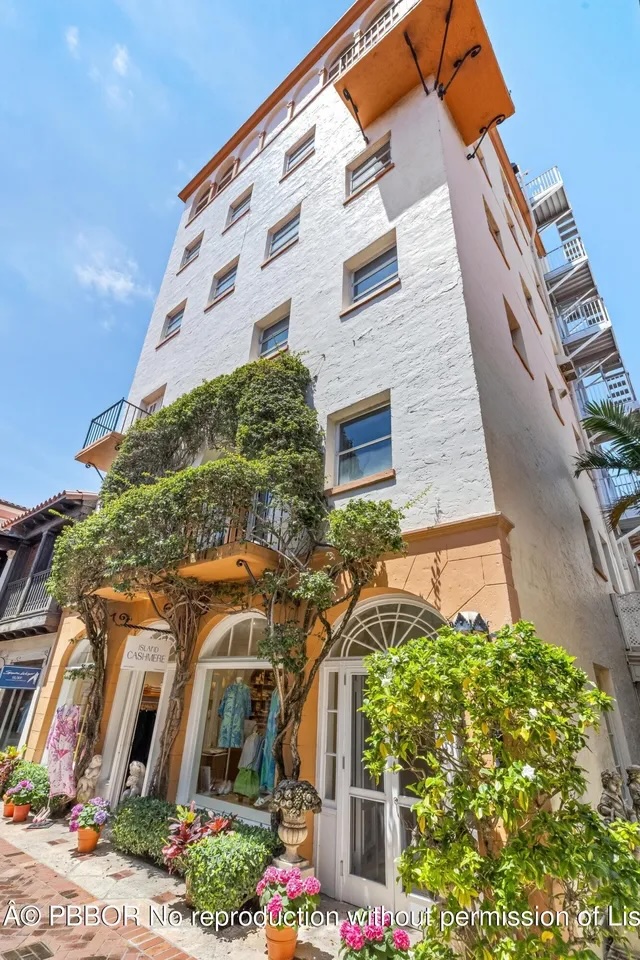 Depicted is a ground-up view of a Mediterranean-style apartment tower with retail space in the bottom floor.