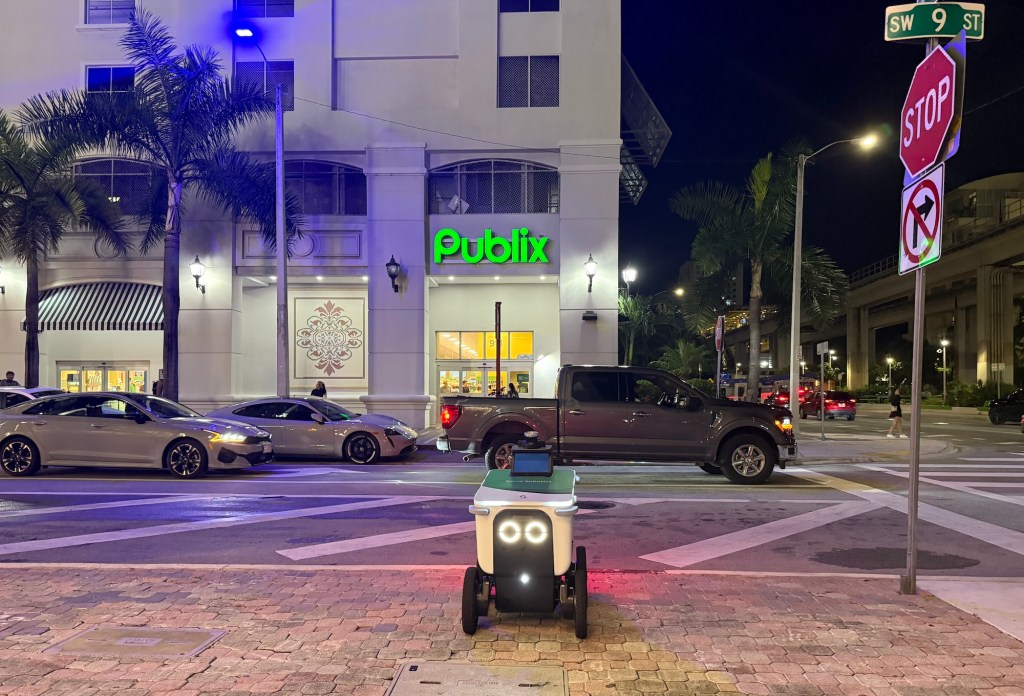 nighttime photo of a delivery robot across the street from a Publix supermarket