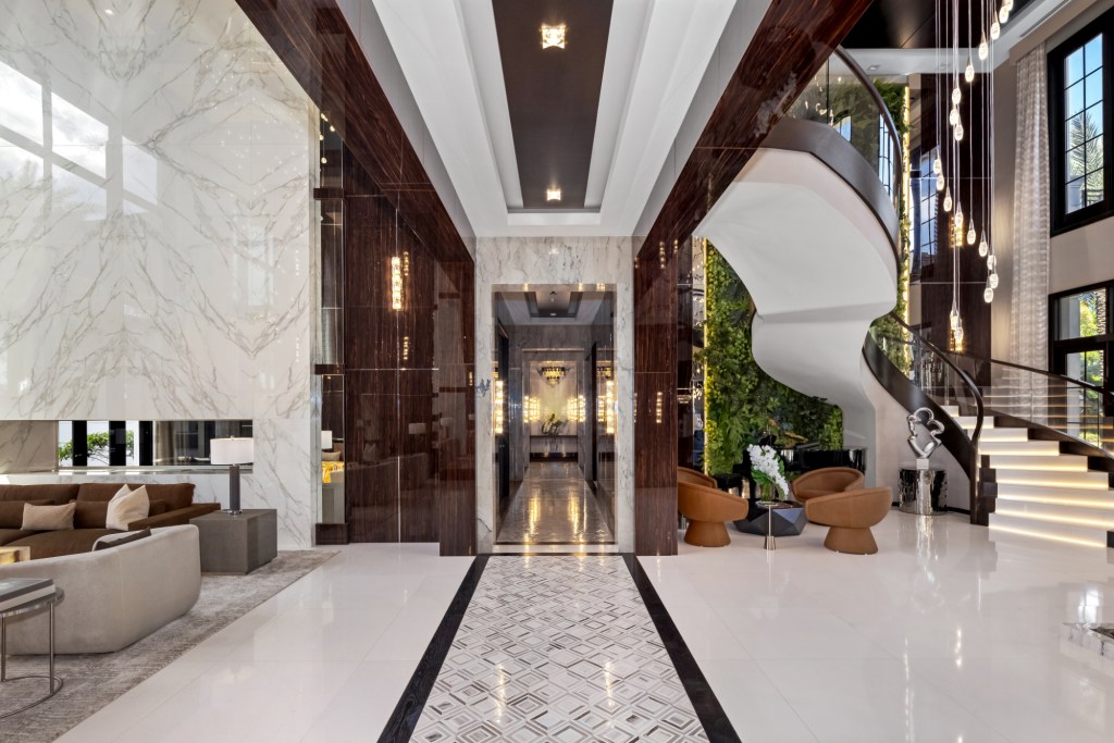 Entrance way with white and wood design with a sprawling staircase