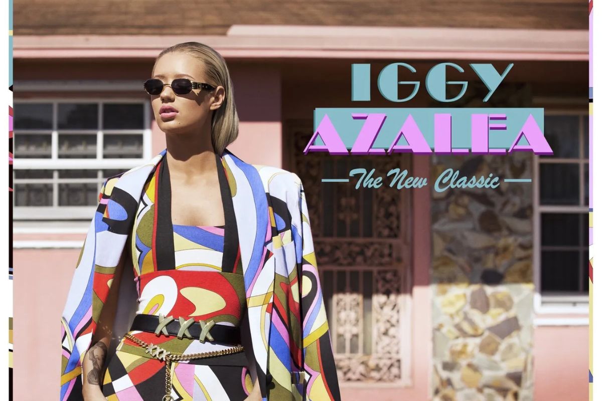 Picture of a woman wearing sunglasses standing in front of a pink house.