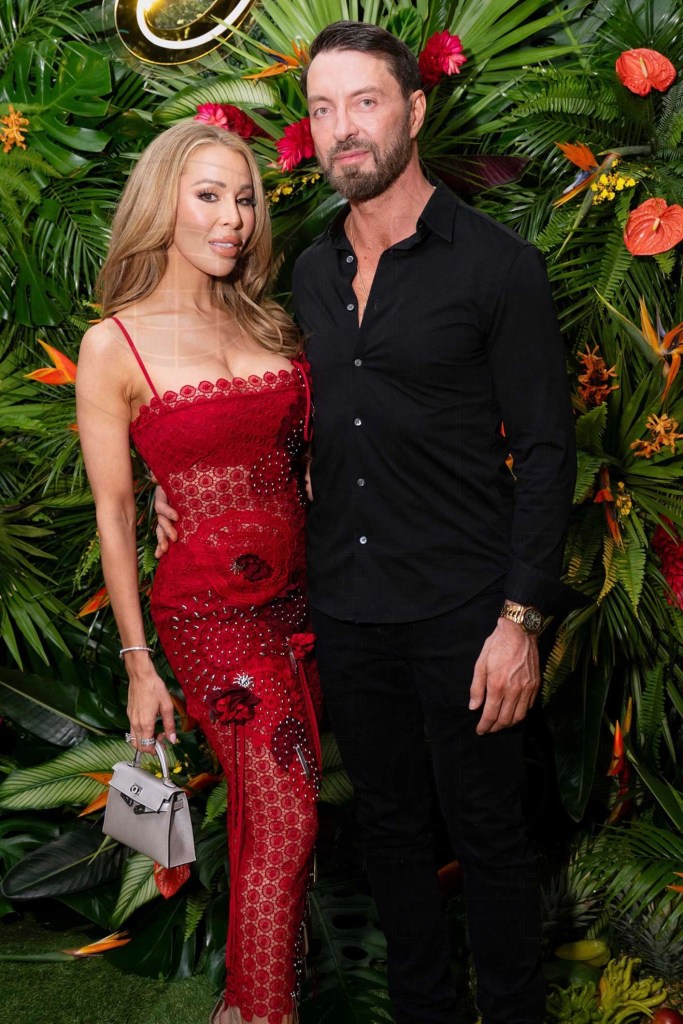Lisa Hochstein poses in a red gown next to Jody Glidden in a black shirt and pants