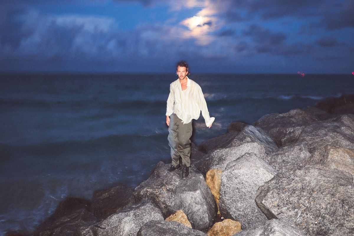 Picture of a man walking next to the ocean.
