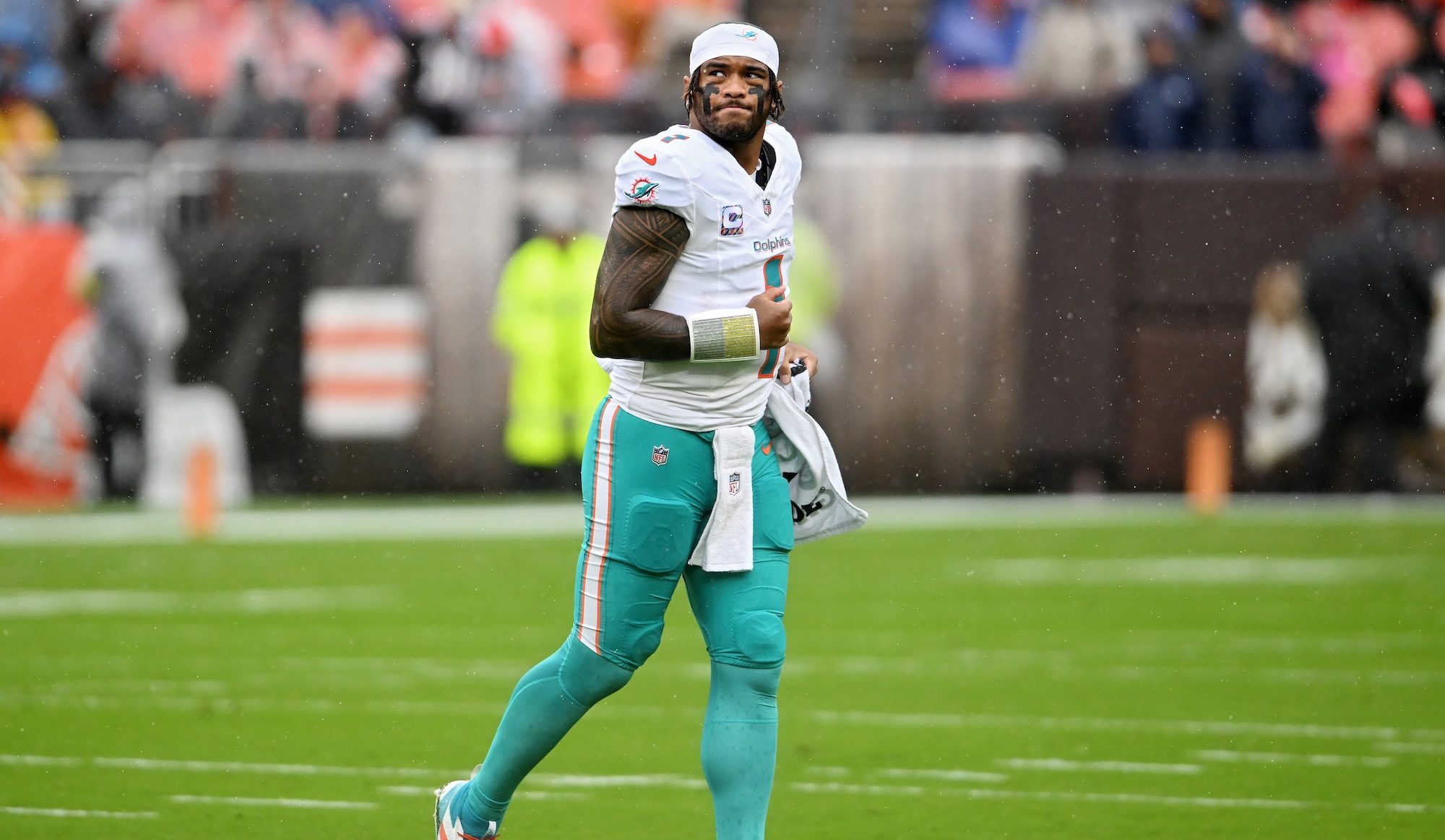miami dolphins quarterback tua tagovailoa on the field before a game, in uniform but without a helmet