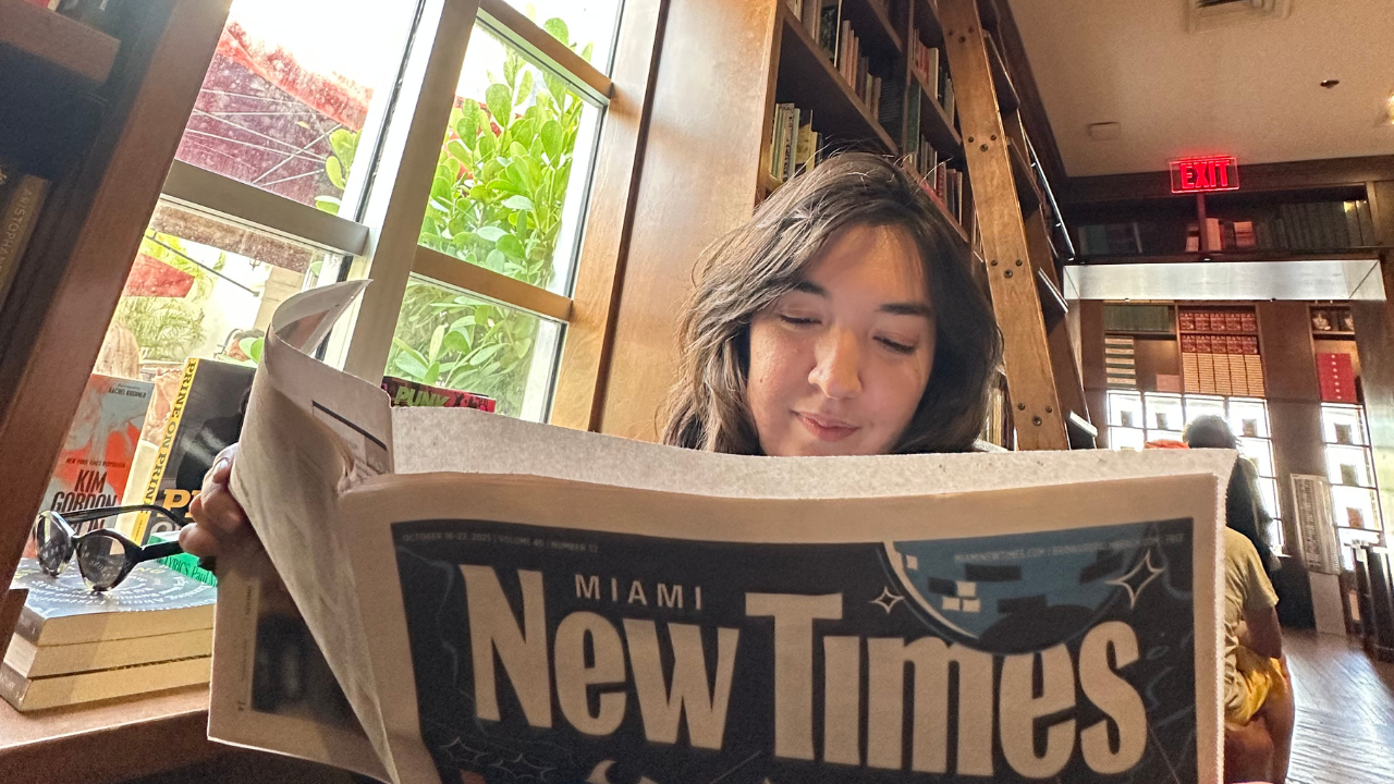photo of a woman reading Miami New Times