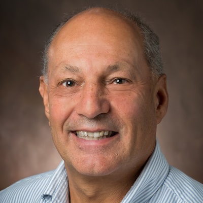 professional headshot of an avuncular-seeming middle-aged man with thinning gray hair