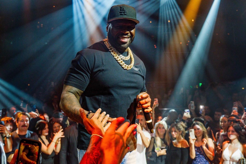photo of rapper 50 cent performing at a club surrounded by audience members
