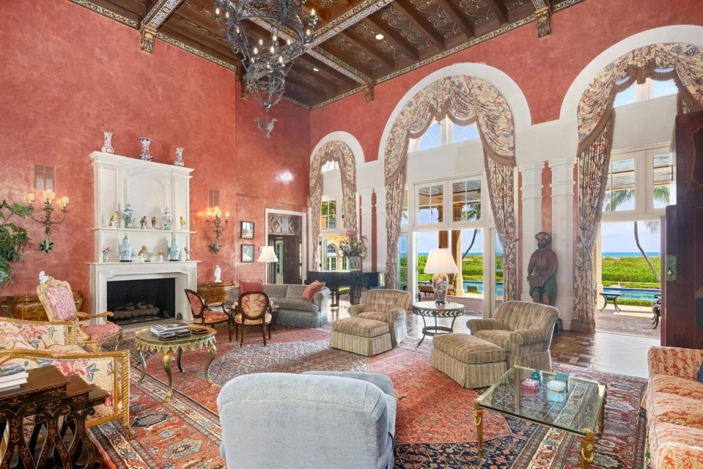 chairs of various designs sit in a salmon-colored living room filled with patterns