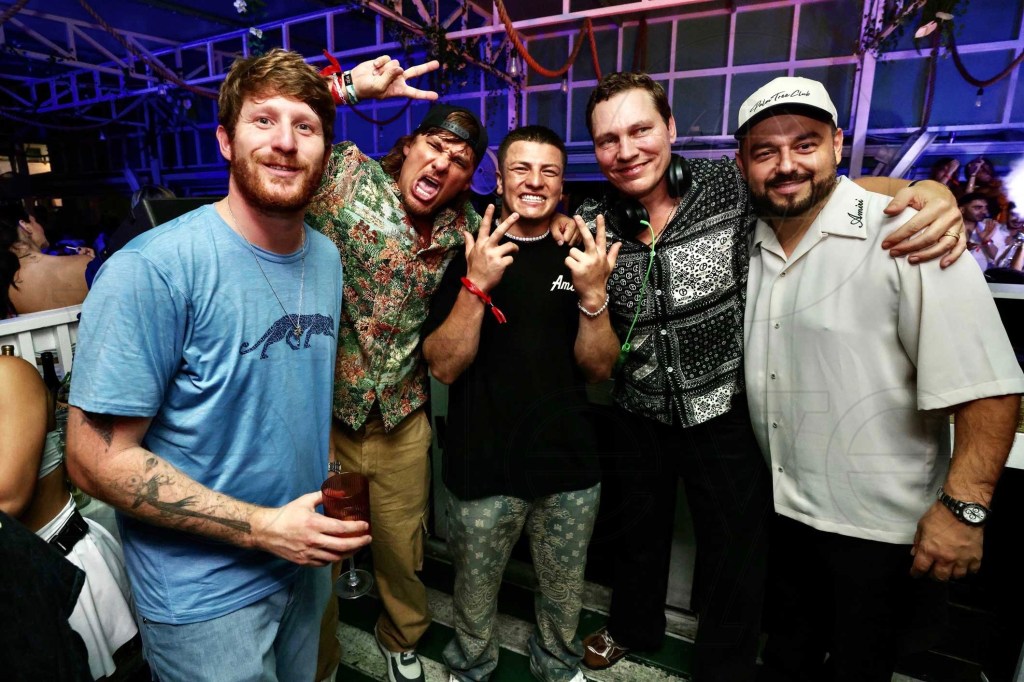 photo of five men in casual wear posing together at a club