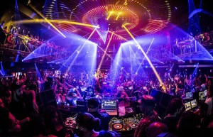 A packed venue with lights shining everywhere