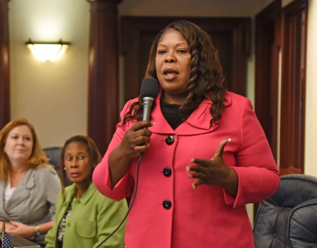 North Miami politician Daphne Campbell holds a microphone while speaking to an audience