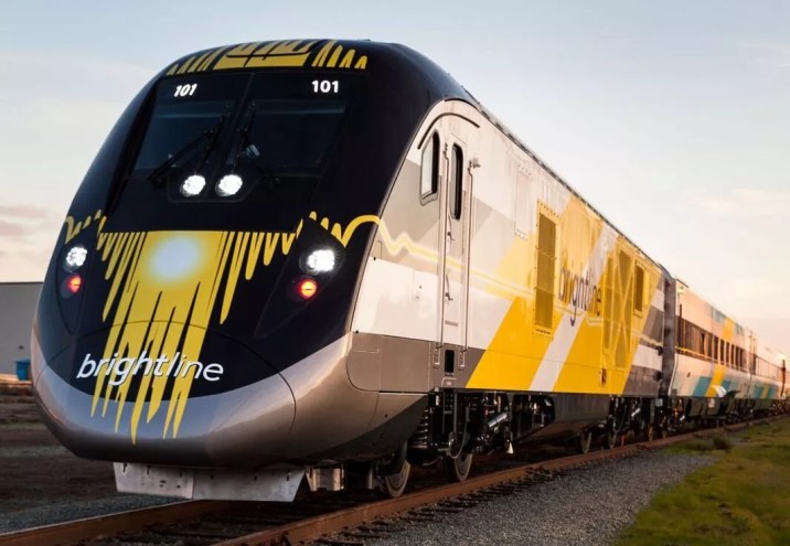 A Brightline train sits on the tracks.