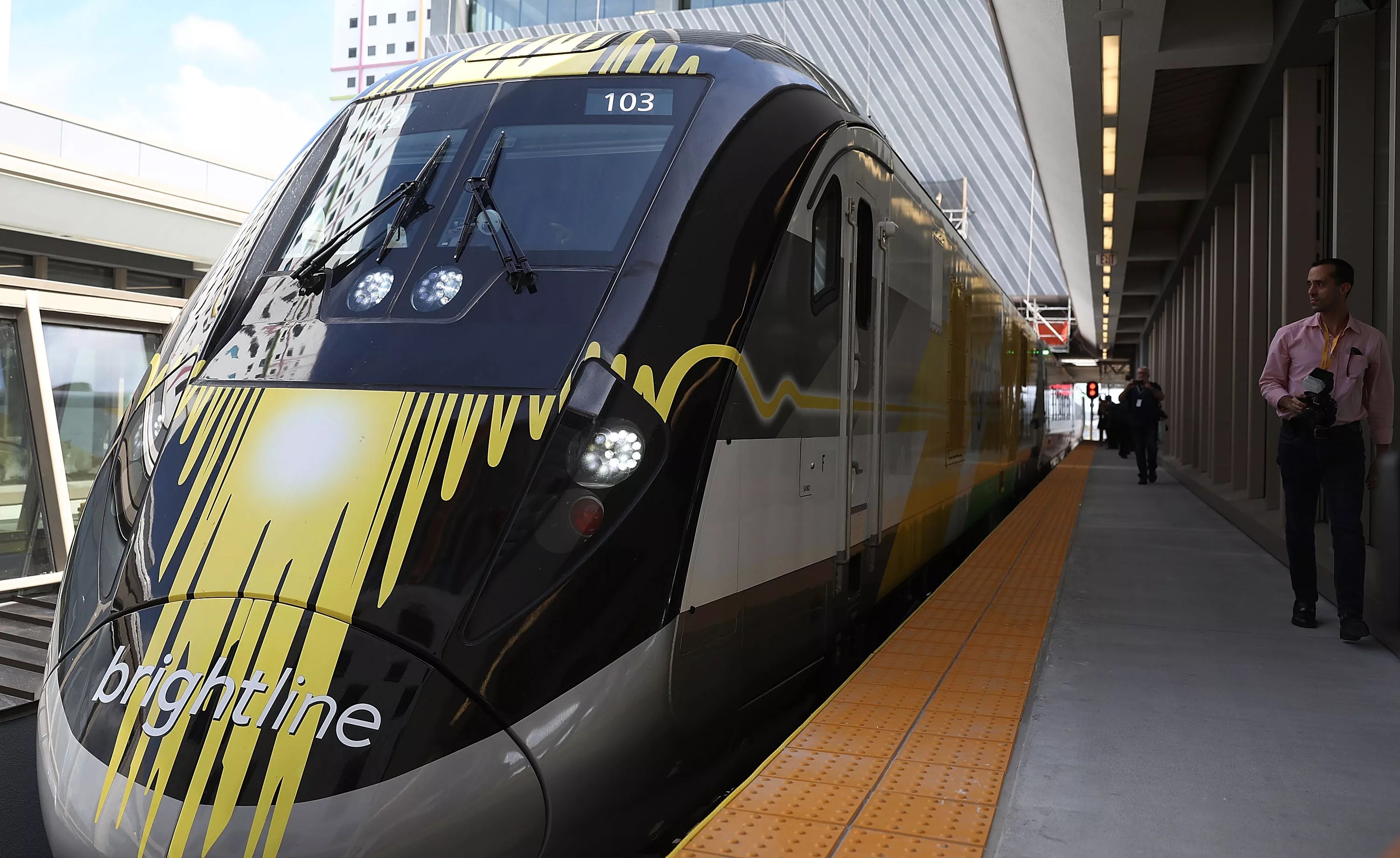 A yellow and black Brightline train sits at the Miami Central terminal.