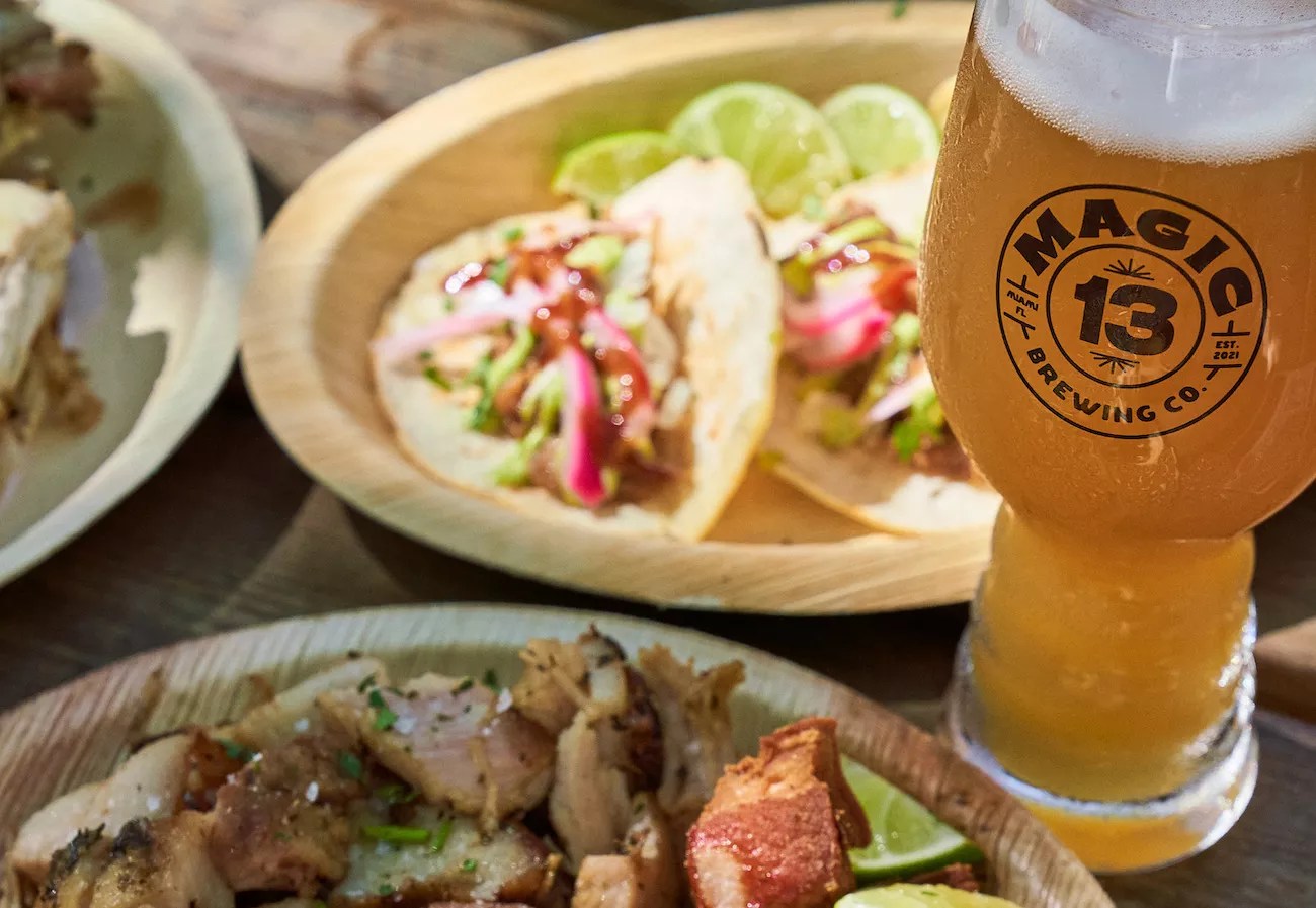A glass of Magic 13 Brewing beer surrounded by food by Meat N' Bone