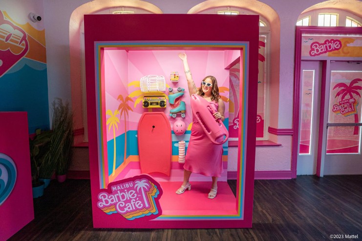 A woman takes a photo at a Malibu Barbie Cafe pop-up.