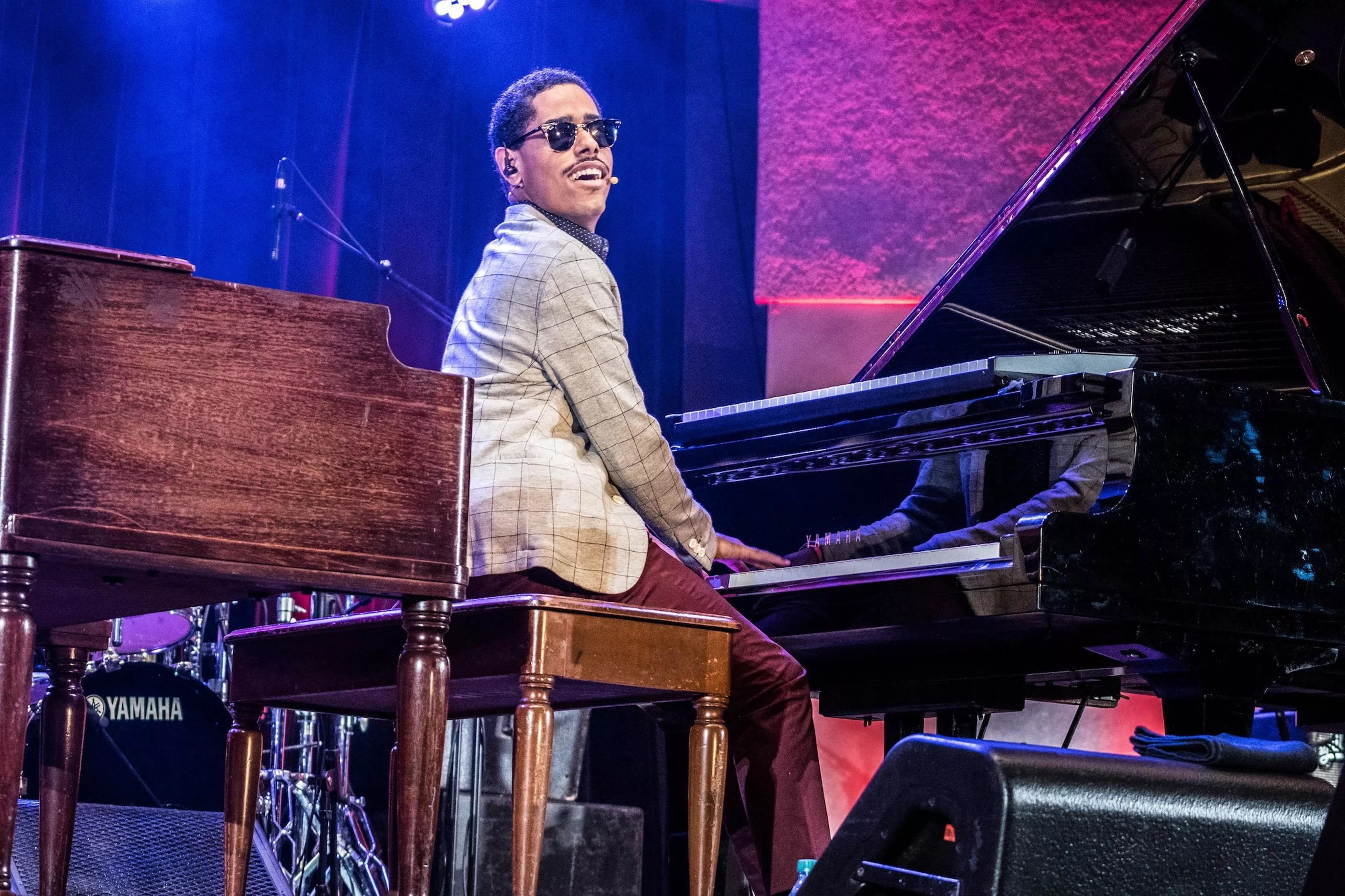 Matthew Whitaker plays the piano on stage