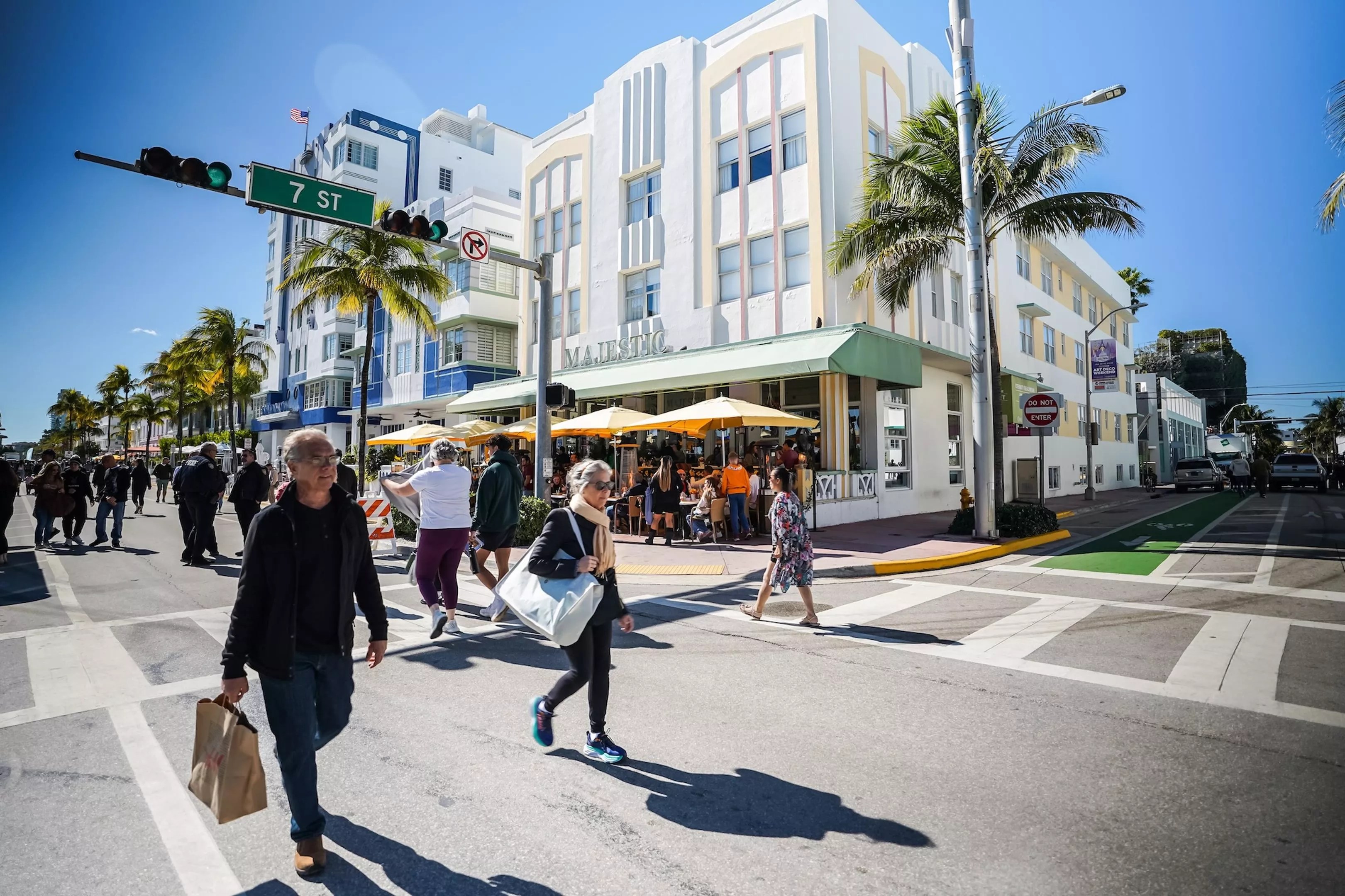 People walking along Ocean Drive in Miami Beach in front of art deco buildings
