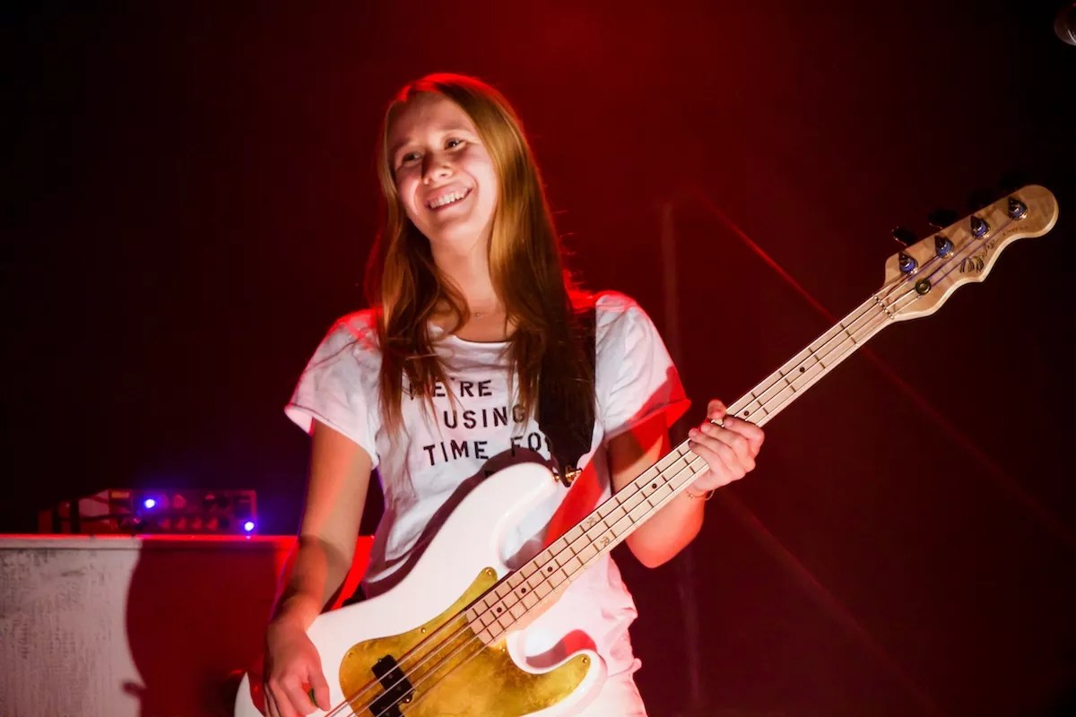 karina rykman in a t-shirt holding a guitar
