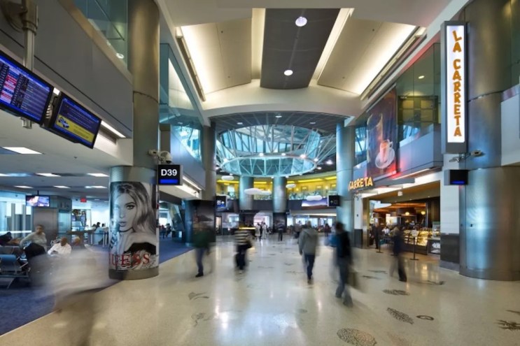 Passengers walk through Concourse D at Miami International Airport.