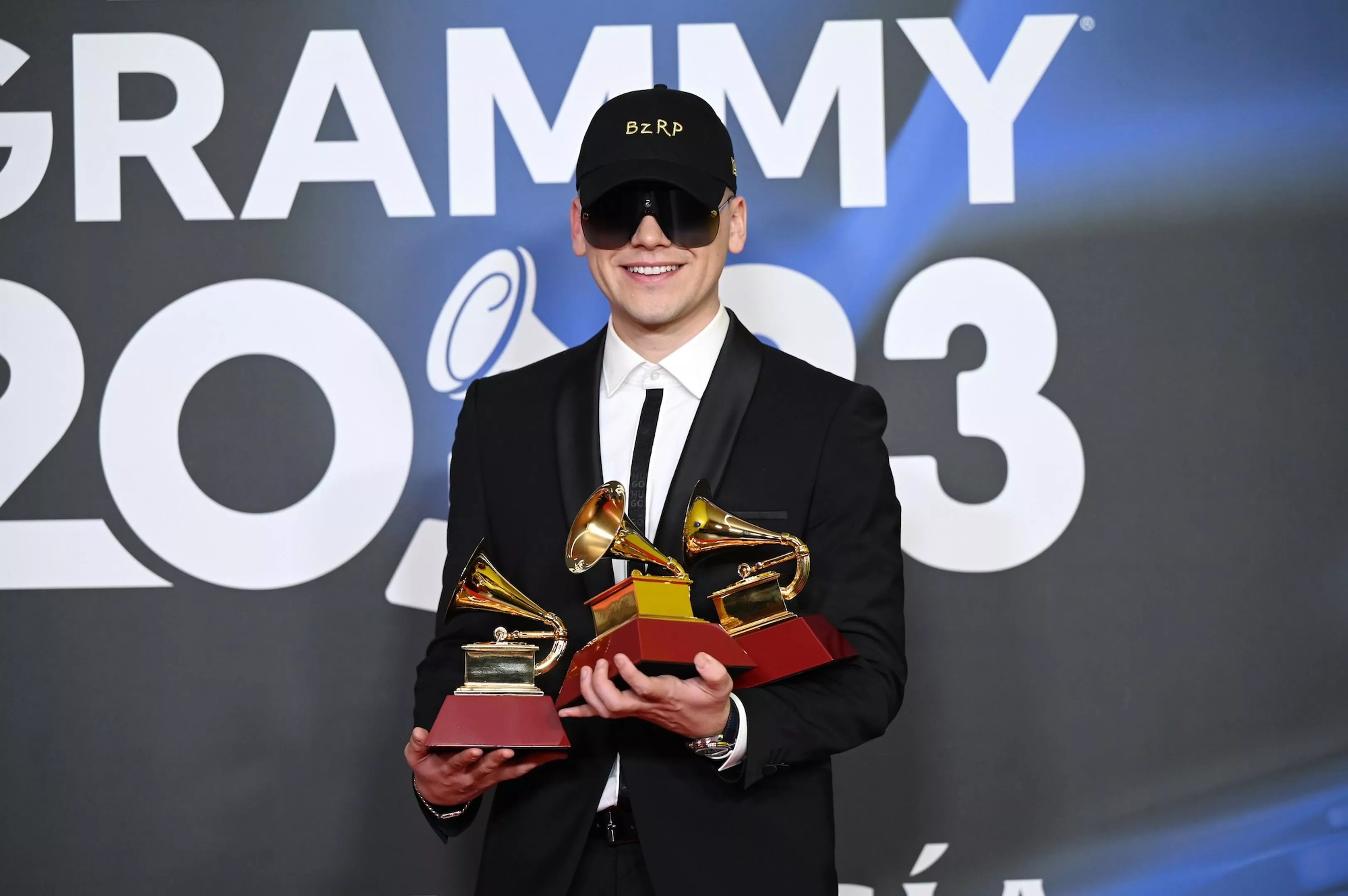 Bizarrap posing with three Latin Grammy trophies in his hands