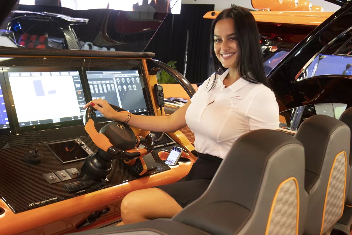 Woman poses at the controls of a boat
