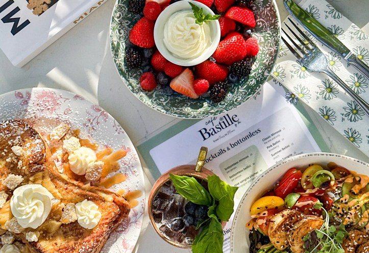 Brunch food spread on a white table with colorful fruit