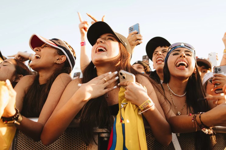 A woman holds a flag as she looks at what is happening on stage