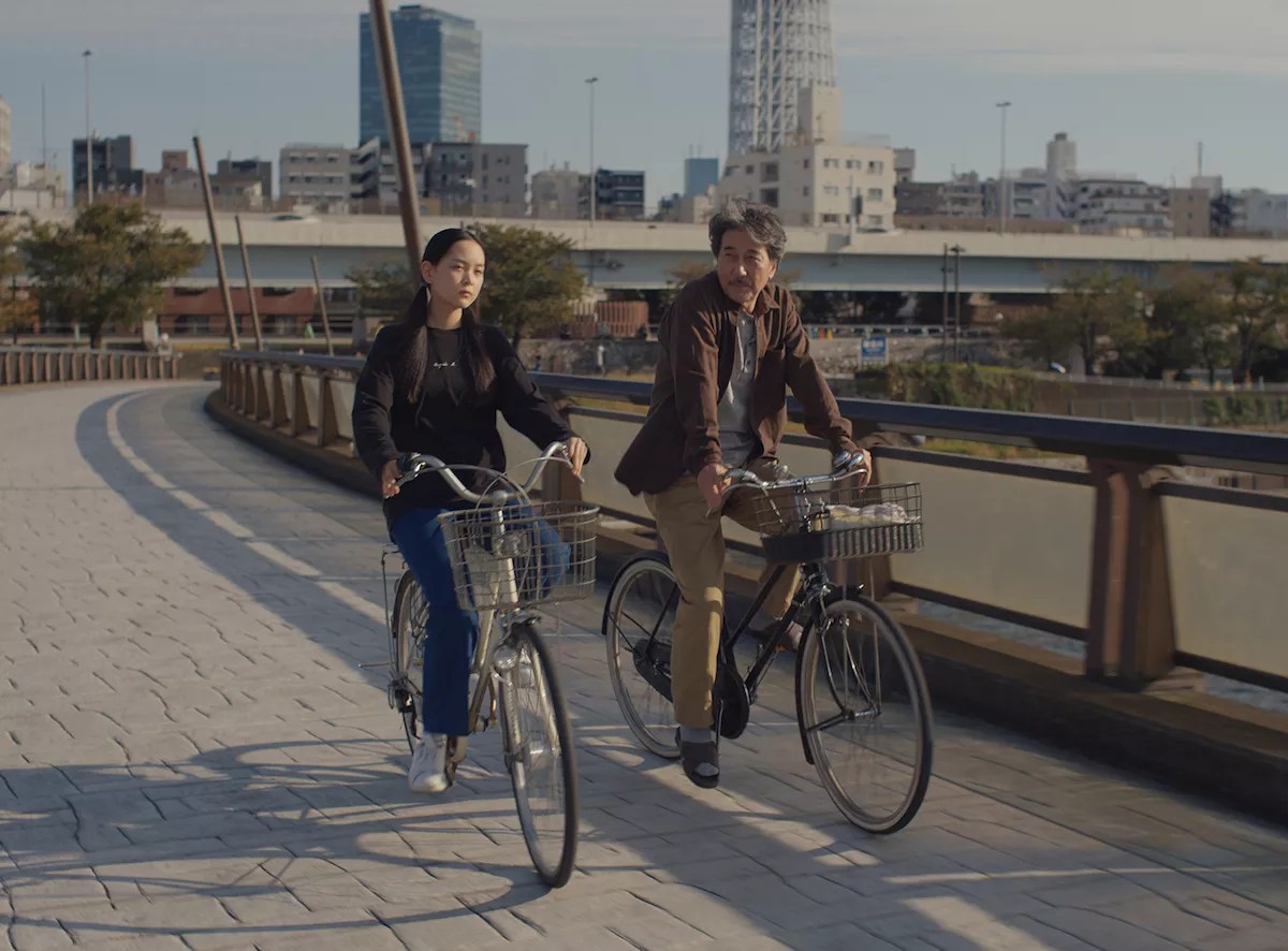 Koji Yakusho and Arisa Nakano on bikes in the film Perfect Days