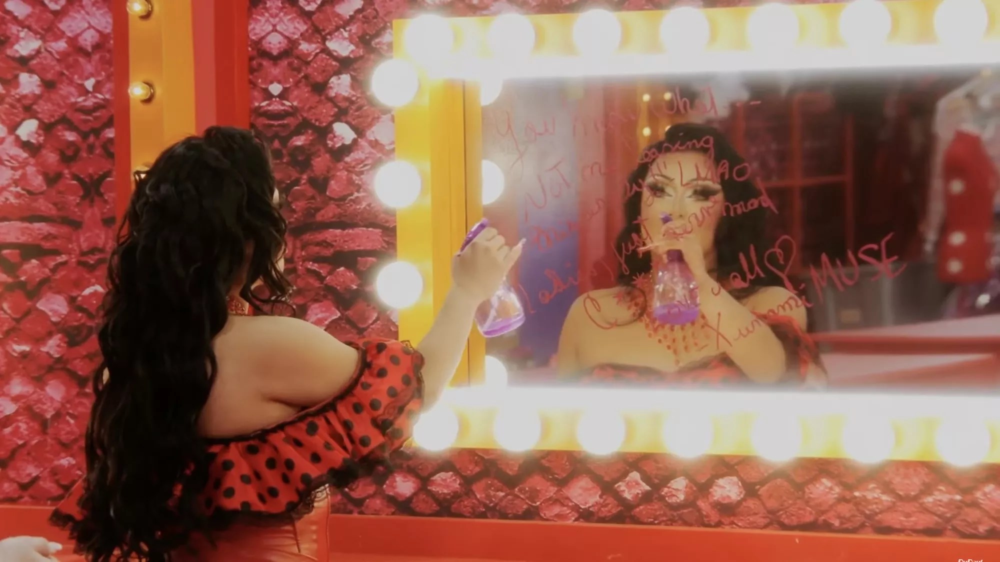 Morphine Love Dion cleaning a message written lip stick from a mirror