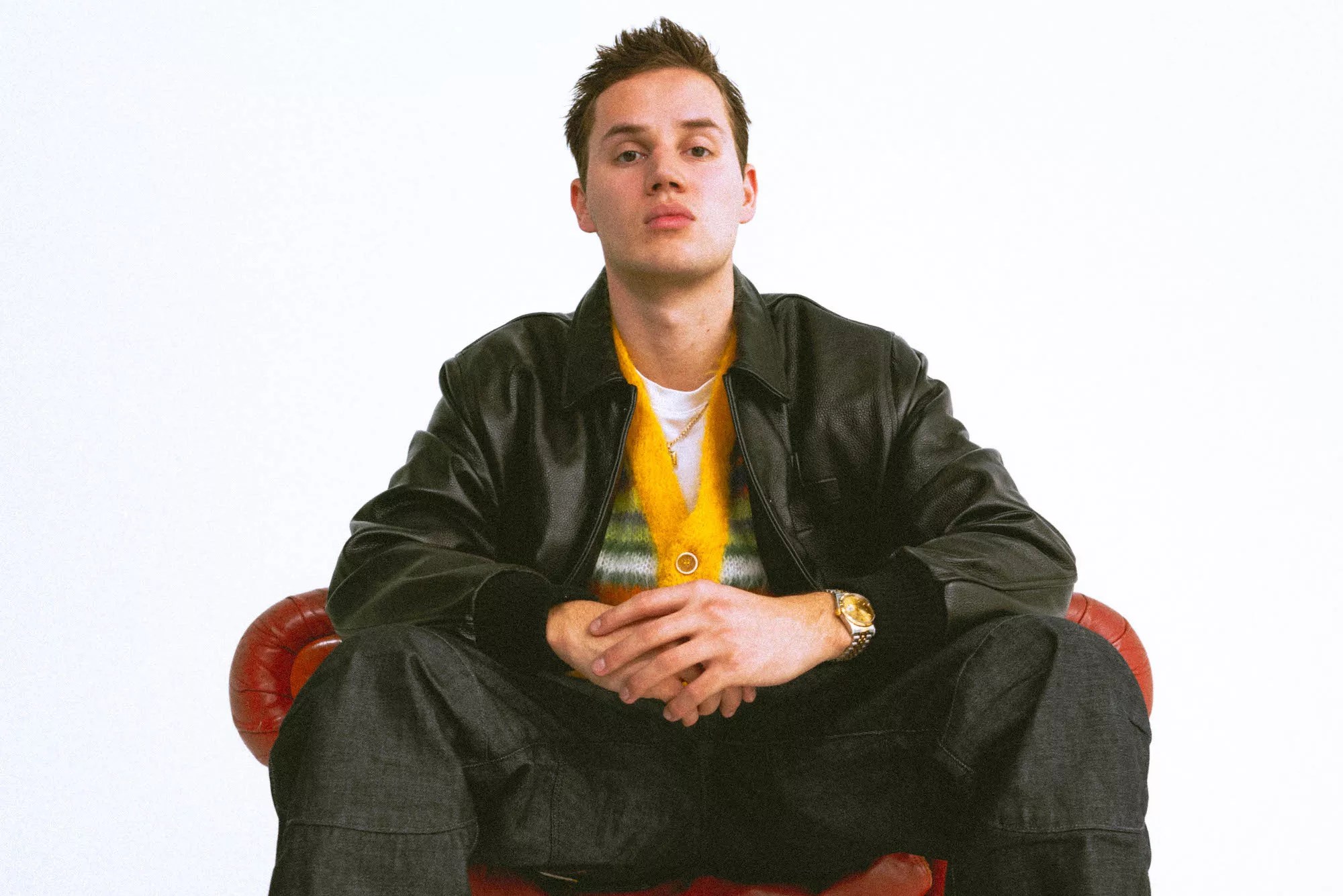 Mau P sitting on a red leather chair