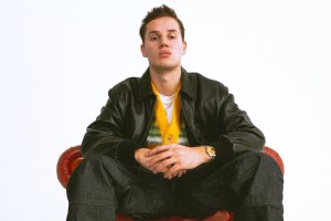 Mau P sitting on a red leather chair