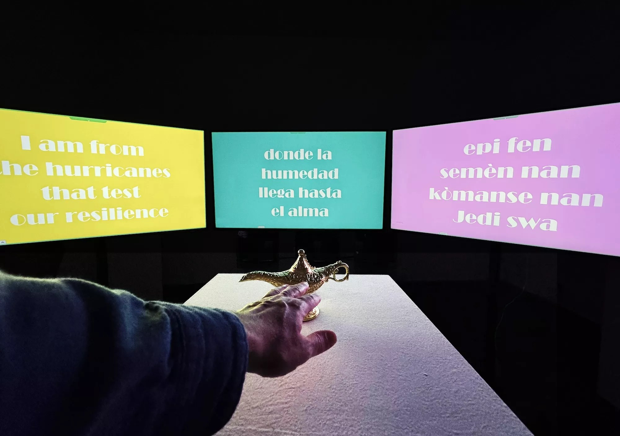 A hand reaching out for a lamp place in front of three screens