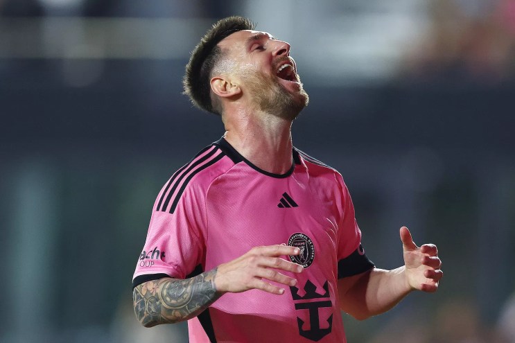 Photo of Inter Miami FC star Lionel Messi, clad in pink and looking ecstatically skyward
