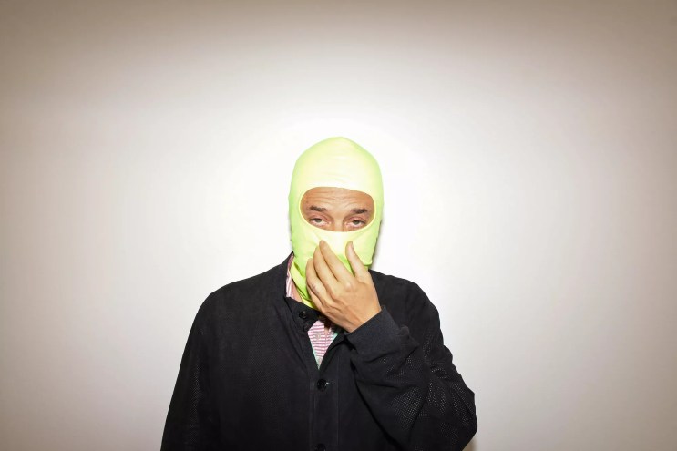 Harmony Korine, with his face covered by a neon-green balaclava