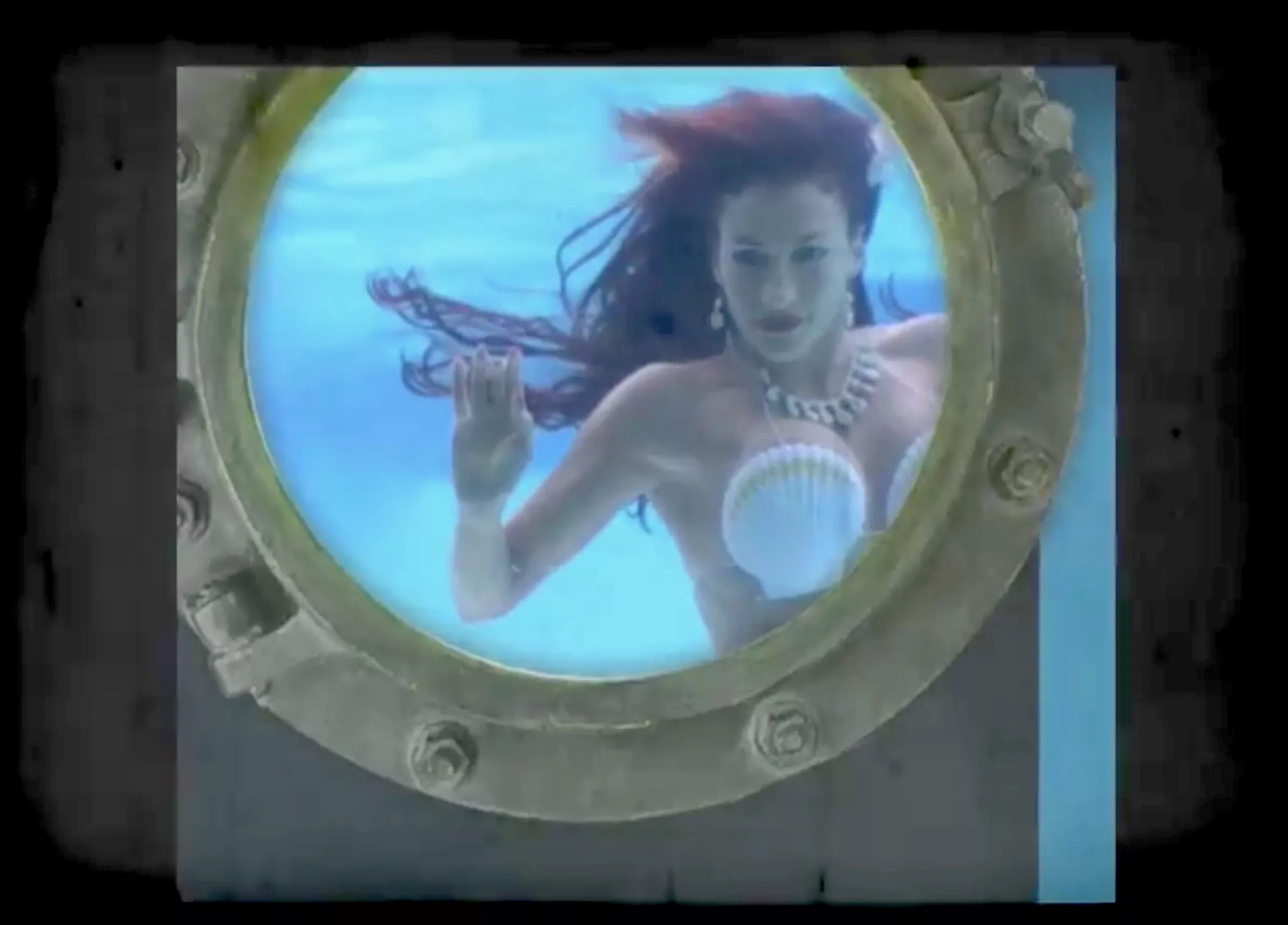 A scantily clad woman in a mermaid costume performs underwater at the Wreck Bar