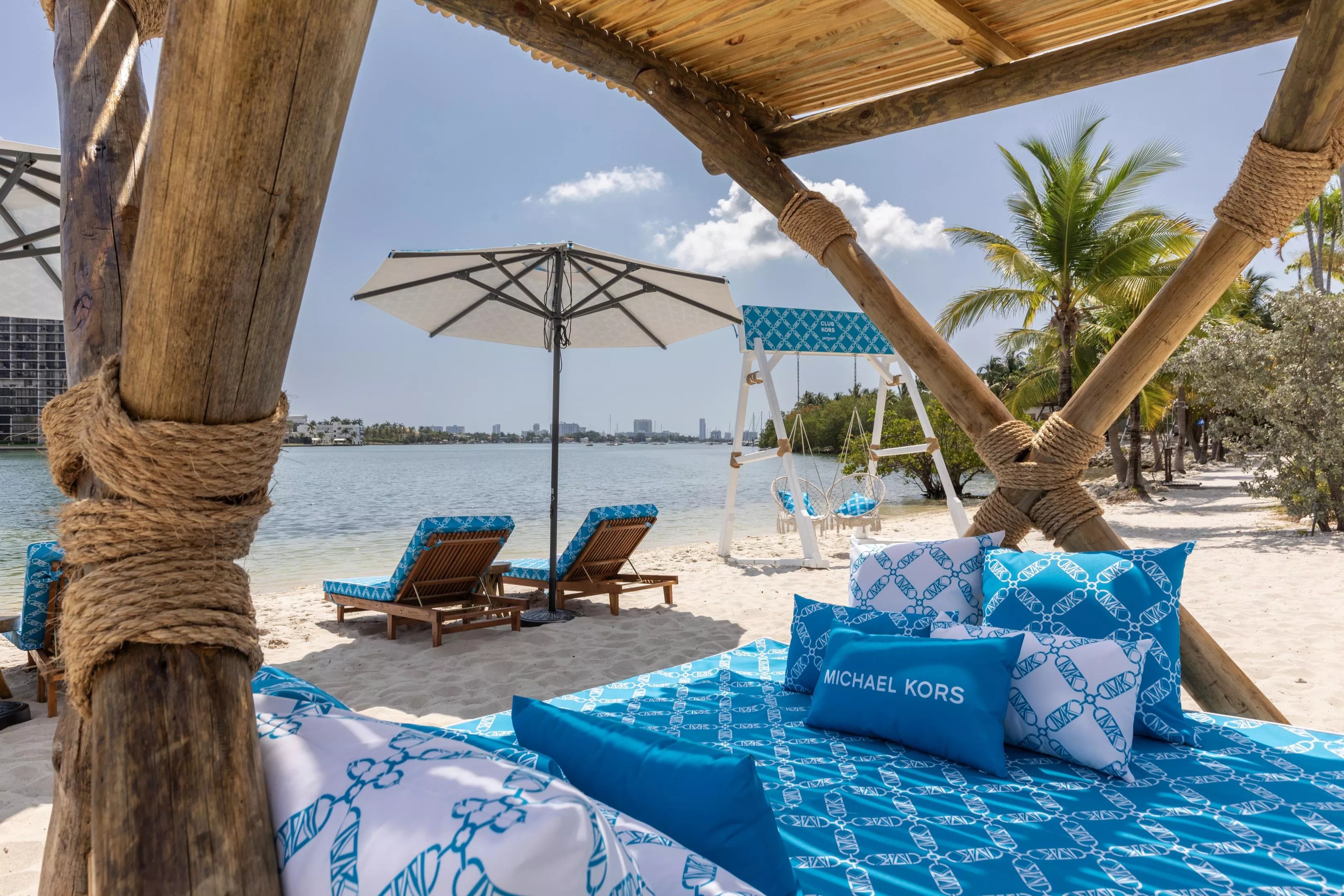 A beach club with blue chairs facing the ocean