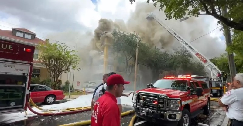 Smoke billows from the Temple Court Apartments in Miami as firefighters scramble to fight the blaze