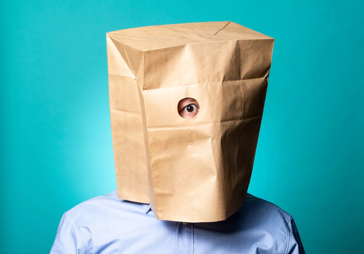 photo of a person with a brown paper bag over their head.