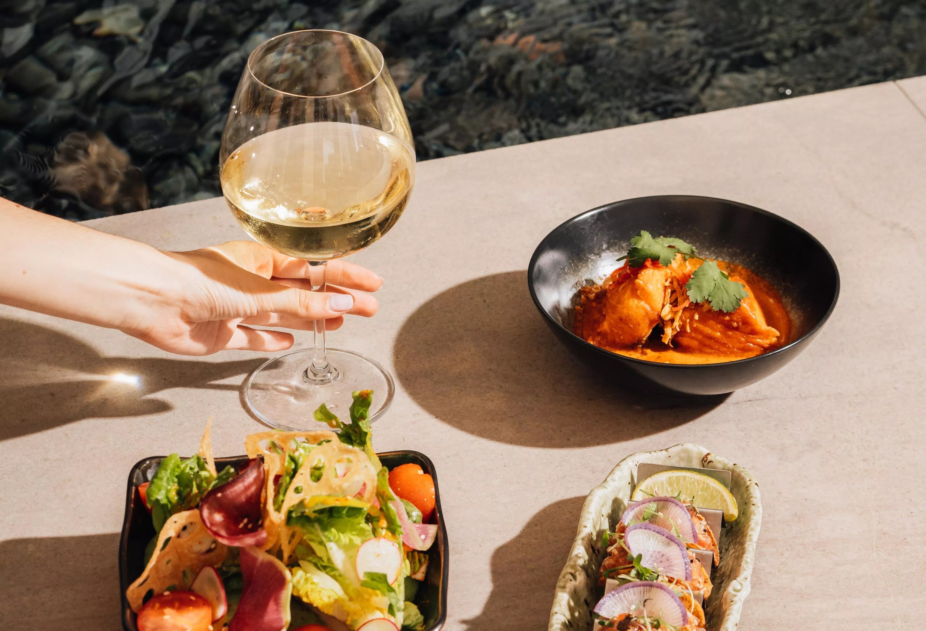 a glass of wine on a table next to plates of food