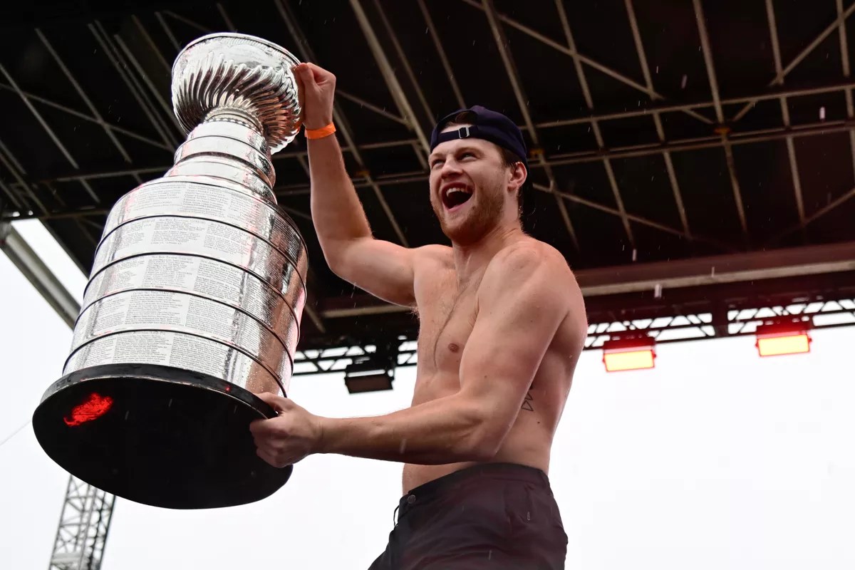 A shirtless Steven Lorentz holding the Stanley Cup trophy