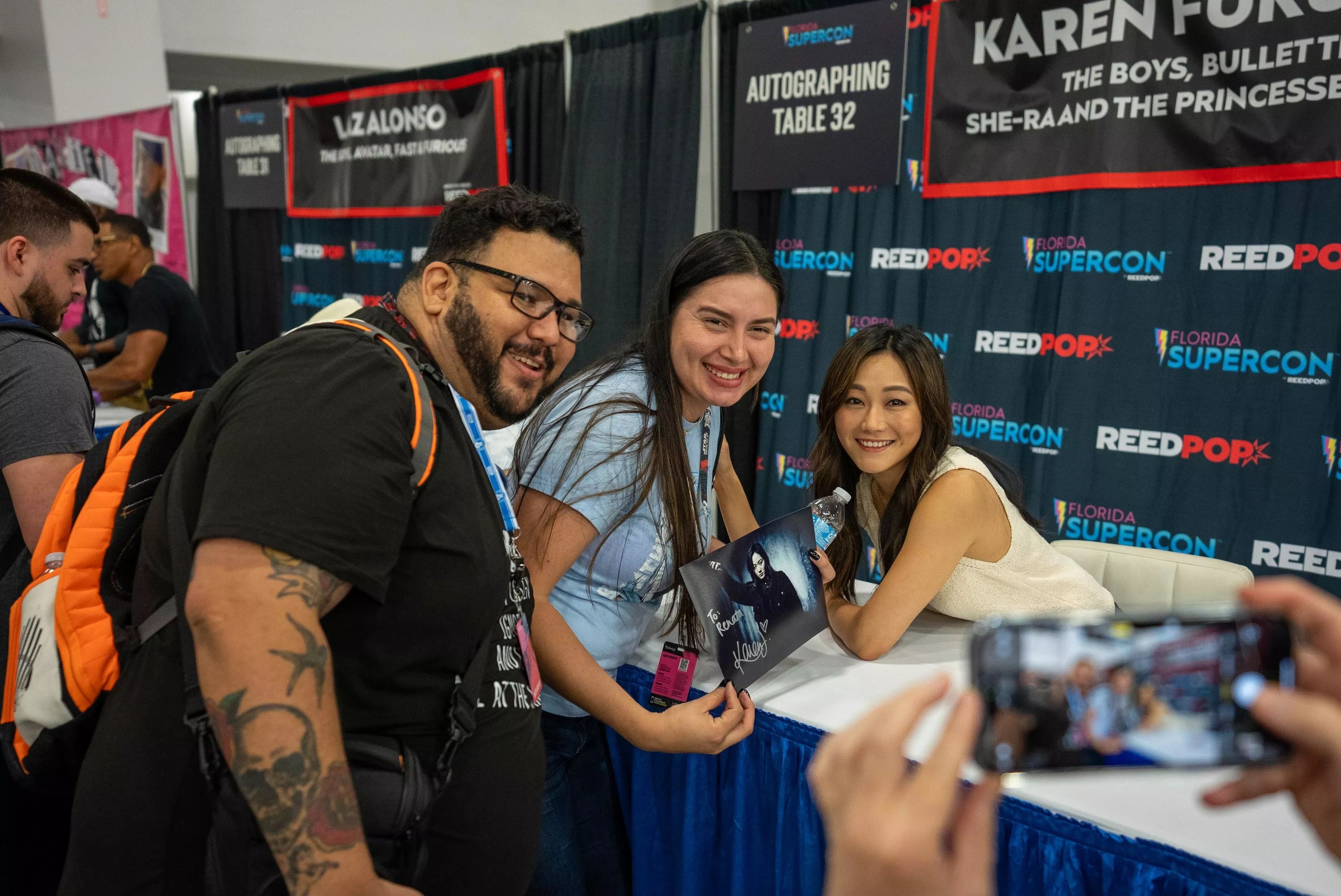 Actress Karen Fukuhara posing with two fans at Florida Supercon