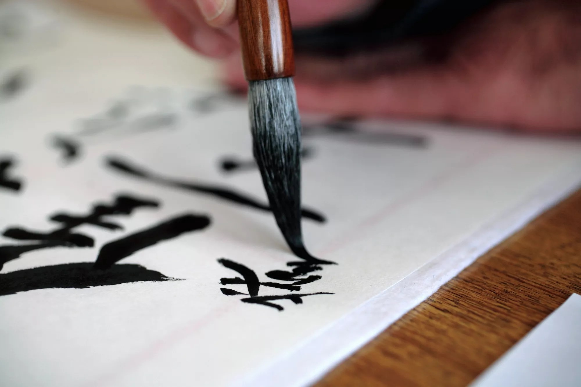 Man doing Japanese calligraphy with a brush