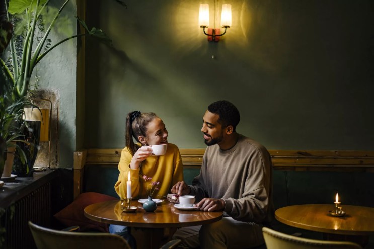 A couple starring at each other in a coffee shop